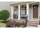 Inviting front porch with decorative columns, hanging flower baskets, seating, and a stone base for a welcoming entrance at 4120 Overcup Oak Ln, Cary, NC 27519
