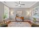 Bright home office showcasing a large window, gray walls, contemporary art, and tray ceiling with fan at 4120 Overcup Oak Ln, Cary, NC 27519