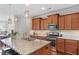 Kitchen with granite countertops, wooden cabinets, stainless steel appliances and a view of a dining area at 4120 Overcup Oak Ln, Cary, NC 27519