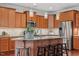 Beautiful kitchen with wood cabinets, granite countertops, stainless appliances, an island with seating, and pendant lighting at 4120 Overcup Oak Ln, Cary, NC 27519