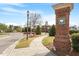 Street view with a brick sign post, showcasing the neighborhood entrance and clubhouse in the background at 4120 Overcup Oak Ln, Cary, NC 27519