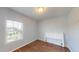 Bright bedroom with wood-look flooring, large window, and a simple headboard at 421 Old Ride Dr, Holly Springs, NC 27540