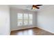 This bedroom features three windows, a ceiling fan, and beautiful hardwood floors at 421 Old Ride Dr, Holly Springs, NC 27540