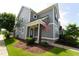 Charming two-story home with gray siding, a covered porch, blue door, and an American flag at 421 Old Ride Dr, Holly Springs, NC 27540