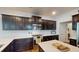 Close-up of modern kitchen featuring dark cabinets, stainless steel appliances, quartz countertops, and tile backsplash at 421 Old Ride Dr, Holly Springs, NC 27540