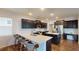 Modern kitchen featuring dark cabinetry, quartz countertops, stainless steel appliances, and seating at the island at 421 Old Ride Dr, Holly Springs, NC 27540