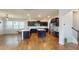 Spacious kitchen featuring dark cabinets, quartz countertops, stainless steel appliances, and seamless transition to living space at 421 Old Ride Dr, Holly Springs, NC 27540