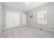Neutral bedroom featuring plush carpeting, double closets, and a window letting in natural light at 43 Salt Cedar Ln, Chapel Hill, NC 27516