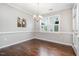 Traditional dining room with hardwood floors, wainscoting, modern chandelier and window with plantation shutters at 43 Salt Cedar Ln, Chapel Hill, NC 27516