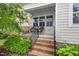 Front porch featuring brick stairs, iron railings, and two wicker chairs for enjoying the outdoors at 43 Salt Cedar Ln, Chapel Hill, NC 27516