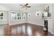 Bright living room with gleaming hardwood floors, fireplace with white mantle, and large windows for natural light at 43 Salt Cedar Ln, Chapel Hill, NC 27516