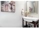 Stylish powder room with a pedestal sink, elegant mirror, and decorative artwork at 43 Salt Cedar Ln, Chapel Hill, NC 27516