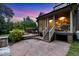 Backyard at dusk with a brick patio, deck, stairs, and a screened in porch at 4720 Yates Mill Pond Rd, Raleigh, NC 27606