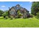 Charming backyard with a deck, a hot tub, a stone outdoor kitchen and lush green lawn at 4720 Yates Mill Pond Rd, Raleigh, NC 27606