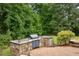 Backyard with a stone outdoor kitchen featuring a built-in grill at 4720 Yates Mill Pond Rd, Raleigh, NC 27606
