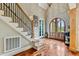 Grand foyer features hardwood floors, staircase with iron railings, and arched doorway at 4720 Yates Mill Pond Rd, Raleigh, NC 27606