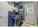 Laundry room with modern, front-loading washer and dryer, cabinets and access to the backyard at 4720 Yates Mill Pond Rd, Raleigh, NC 27606