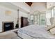 Bright main bedroom features a stone fireplace and a private balcony for enjoying a morning coffee at 4720 Yates Mill Pond Rd, Raleigh, NC 27606