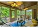 Inviting screened porch featuring multiple ceiling fans, furniture, and views of the outdoor scenery at 4720 Yates Mill Pond Rd, Raleigh, NC 27606
