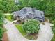 Expansive estate home with lush landscaping, mature trees, and long driveway surrounded by greenery at 4924 Stoneyoak Ln, Raleigh, NC 27610