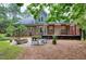Spacious backyard with a stone patio, a fire pit, shade trees and an expansive deck with cable railing at 4924 Stoneyoak Ln, Raleigh, NC 27610