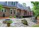 Exterior view of a large backyard featuring a stone patio, a fire pit and an expansive deck with cable railing at 4924 Stoneyoak Ln, Raleigh, NC 27610