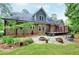 Backyard featuring a stone patio, a fire pit, lush plants and an expansive deck with a cable railing at 4924 Stoneyoak Ln, Raleigh, NC 27610
