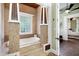 Luxurious bathroom featuring a soaking tub with stone surround, stone floors and views of the main bedroom at 4924 Stoneyoak Ln, Raleigh, NC 27610