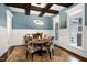 Stylish dining room with dark wood beams, wainscoting, and a modern light fixture at 4924 Stoneyoak Ln, Raleigh, NC 27610