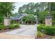 Long private driveway leading to a charming home with stone pillars and lush greenery at 4924 Stoneyoak Ln, Raleigh, NC 27610