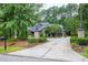 Long private driveway leading to a charming home with stone pillars and lush greenery at 4924 Stoneyoak Ln, Raleigh, NC 27610