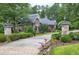 Long private driveway leading to a charming home with stone pillars and lush greenery at 4924 Stoneyoak Ln, Raleigh, NC 27610