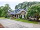 Charming stone house boasts a spacious driveway, lush lawn, and blooming tree at 4924 Stoneyoak Ln, Raleigh, NC 27610