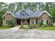 Stunning stone-clad home with beautiful landscaping, mature trees, and a classic architectural design at 4924 Stoneyoak Ln, Raleigh, NC 27610