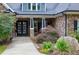 Inviting front entrance with a stylish glass front door, stone accents, and lush landscaping at 4924 Stoneyoak Ln, Raleigh, NC 27610