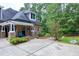 Charming brick home with stone accents, landscaped yard, and inviting front porch with seating at 4924 Stoneyoak Ln, Raleigh, NC 27610