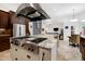 A gourmet kitchen with stainless steel appliances and a large island with a cooktop and stone countertops at 4924 Stoneyoak Ln, Raleigh, NC 27610