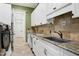 Well-lit laundry room features modern appliances, sink, and stone countertop at 4924 Stoneyoak Ln, Raleigh, NC 27610