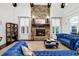 Inviting living room with stone fireplace, beams, and comfortable blue leather seating at 4924 Stoneyoak Ln, Raleigh, NC 27610