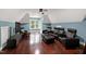 Spacious living room with hardwood floors, a ceiling fan, and comfortable black leather seating at 4924 Stoneyoak Ln, Raleigh, NC 27610
