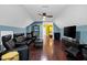 Open-concept living room featuring hardwood floors, comfortable black leather seating and a ceiling fan at 4924 Stoneyoak Ln, Raleigh, NC 27610