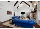 Bright living room featuring stone fireplace, mounted TV, wooden beams, and comfortable sofas at 4924 Stoneyoak Ln, Raleigh, NC 27610