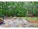 The stone patio features a fire pit, seating, and beautiful landscaping at 4924 Stoneyoak Ln, Raleigh, NC 27610