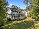 A spacious backyard featuring a pristine lawn, trees, and a charming screened-in porch at 5034 Blendon Trl, Garner, NC 27529