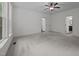 Spacious bedroom features plush carpet, three large windows, ceiling fan, and ensuite bathroom at 5034 Blendon Trl, Garner, NC 27529