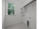 Well-lit laundry room featuring a window, shelving, and utility connections at 5034 Blendon Trl, Garner, NC 27529