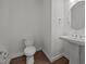 A minimalist powder room featuring a pedestal sink, round mirror, and modern fixtures at 5034 Blendon Trl, Garner, NC 27529