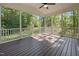 Enjoy the outdoors from this screened-in porch with dark wood flooring and a ceiling fan at 5034 Blendon Trl, Garner, NC 27529
