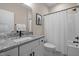 Well-lit bathroom features a granite-topped vanity, white cabinets, and a shower-tub combination with a white shower curtain at 515 N Churton St # 203, Hillsborough, NC 27278
