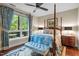 Inviting bedroom with a four-poster bed, blue bedding, and large windows with backyard view at 515 N Churton St # 203, Hillsborough, NC 27278